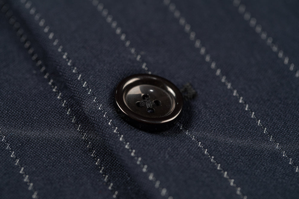 Close-up of dark button on navy chalk stripe pinstripe blazer