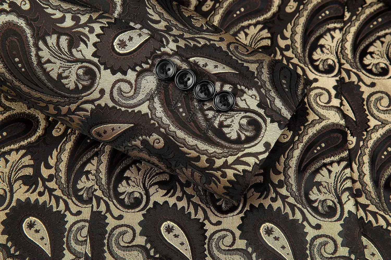Close-up of the cuff section of a paisley-patterned men's blazer with four black buttons, emphasizing the elegant paisley design on the fabric.
