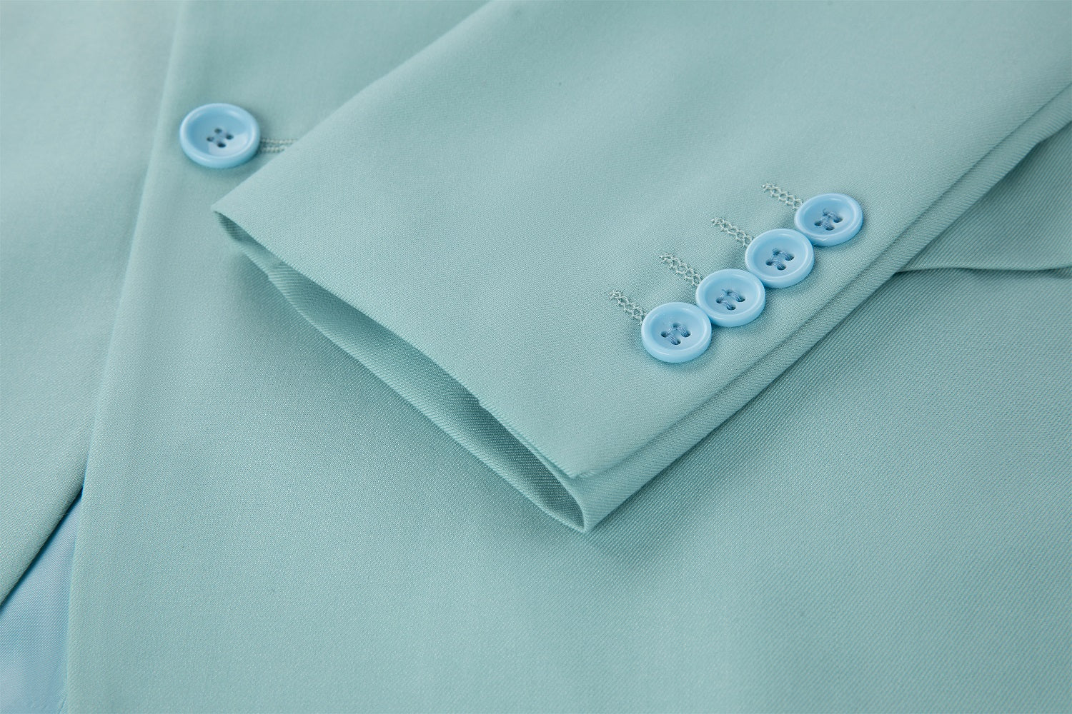 Men's mint green two button blazer cuff detail - four light blue buttons with silver chain links on smooth fabric