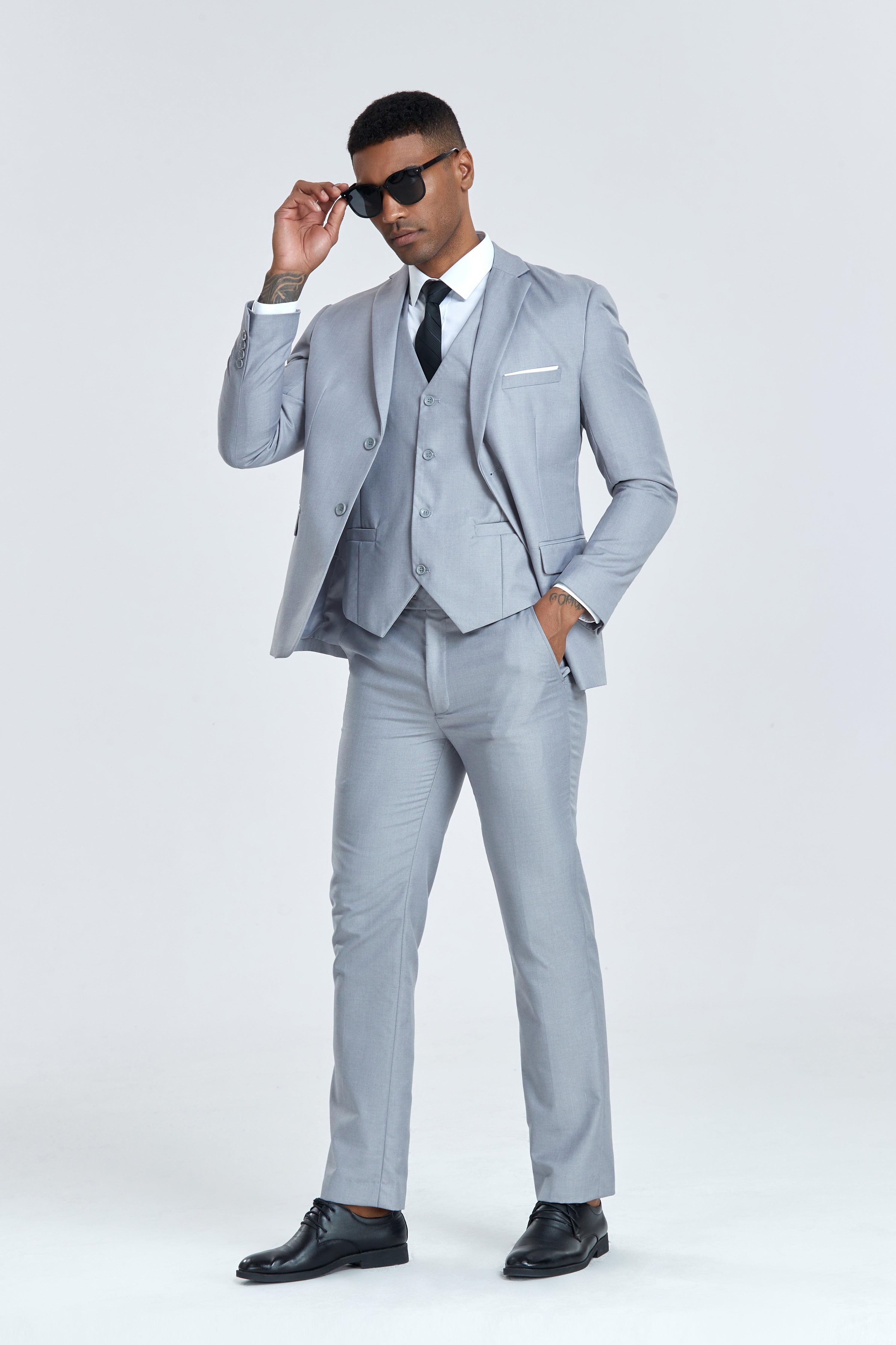 Modern grey men's three piece suit styled with vest and sunglasses, party-ready outfit