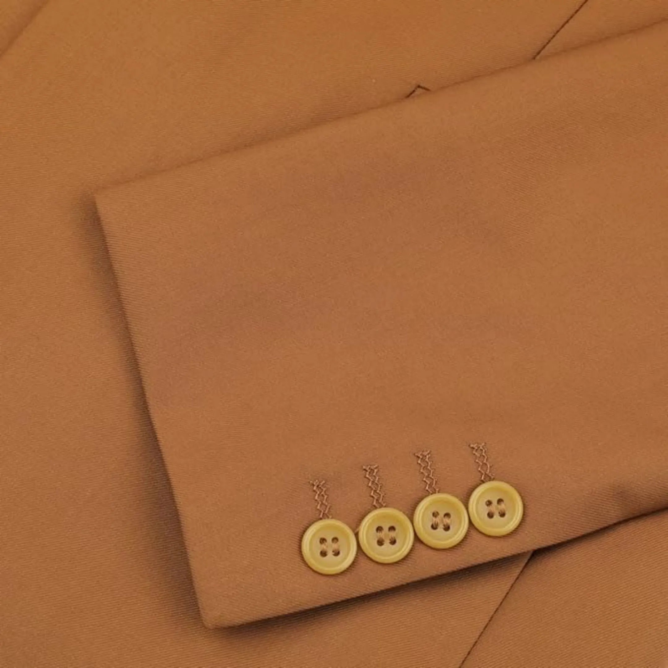 close-up of men's caramel single-breasted blazer showing the button cuffs and fine stitching, adding a refined touch to the design.