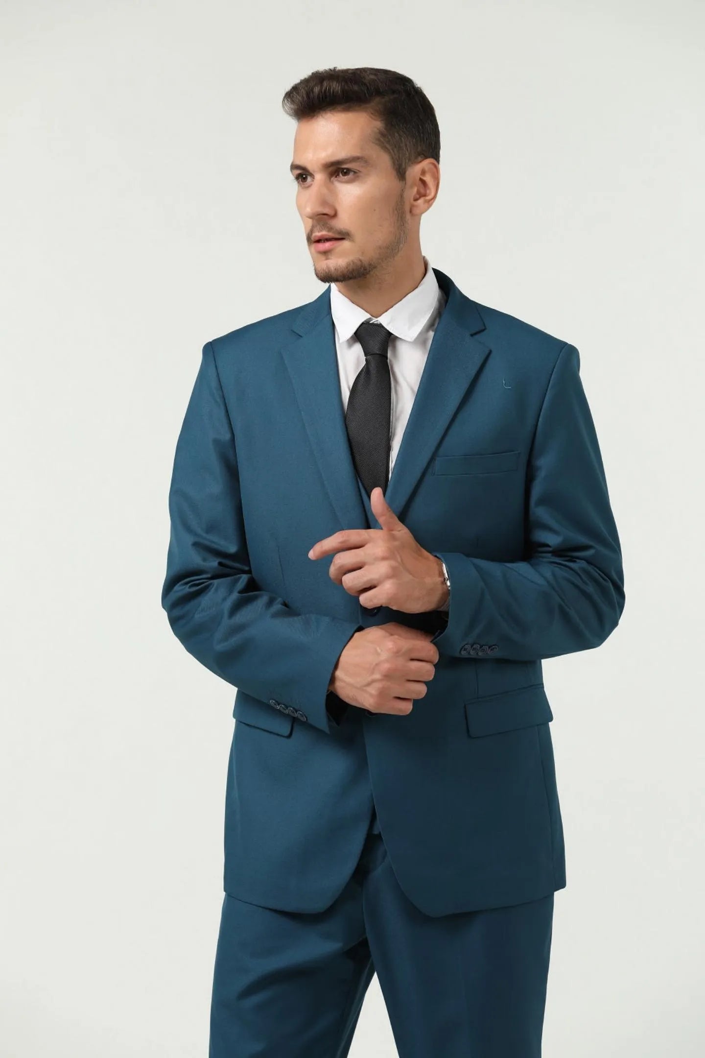close-up of a man in a lake blue slim fit two-button 3-piece suit, standing confidently and adjusting the jacket collar.