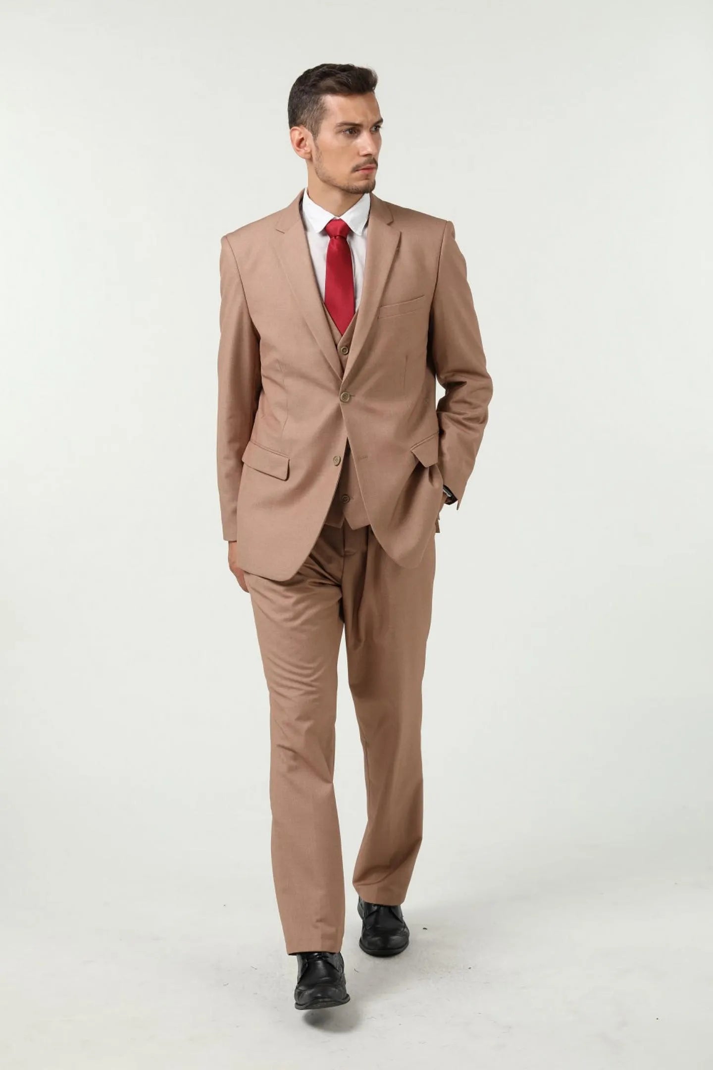 model wearing a champagne colored men's slim fit two-button 3-piece suit with red tie, full-body front view.