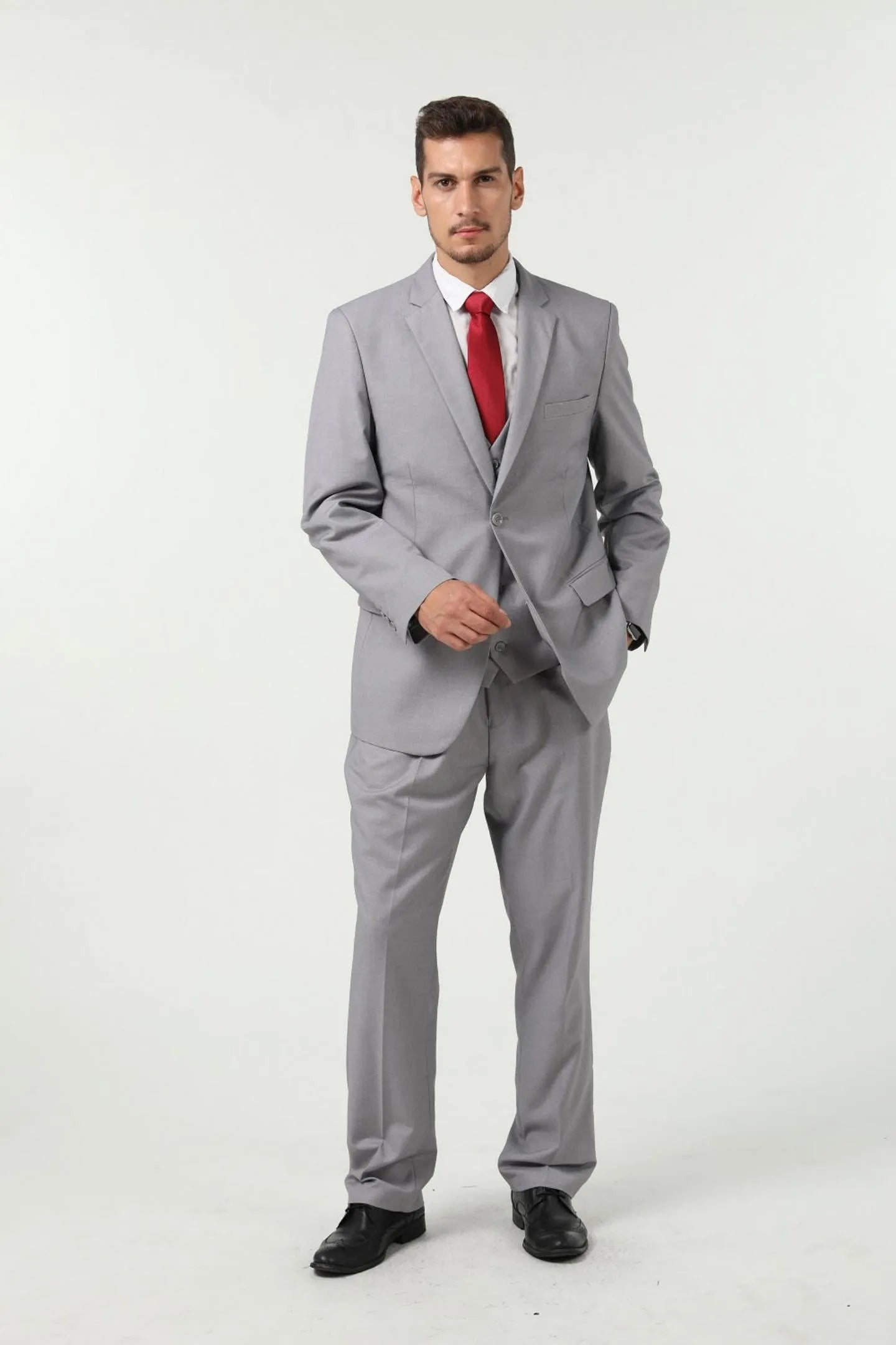 full body view of man in grey slim fit two-button 3-piece suit with red tie, tailored business style.