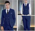 Load image into Gallery viewer, model wearing navy blue double-breasted 3 piece suit – blazer, vest and trousers shown with formal tie in indoor setting