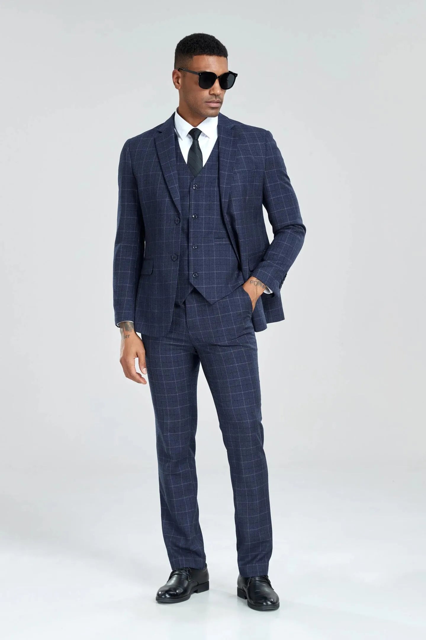 three-quarter left view of navy plaid suit, jacket open to show vest, business-casual attire.