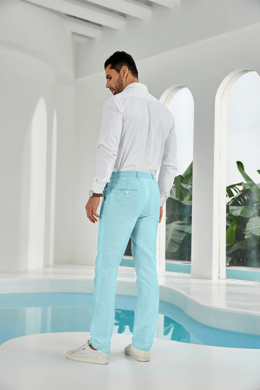 Three-quarter rear angle of aqua pants showing slim fit and texture