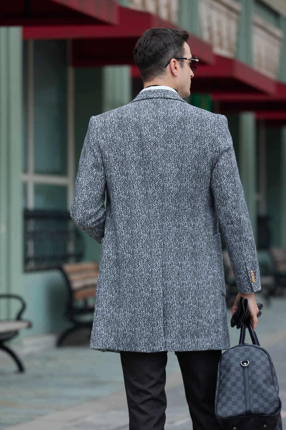 Back view of black and white herringbone wool coat for men – street outfit