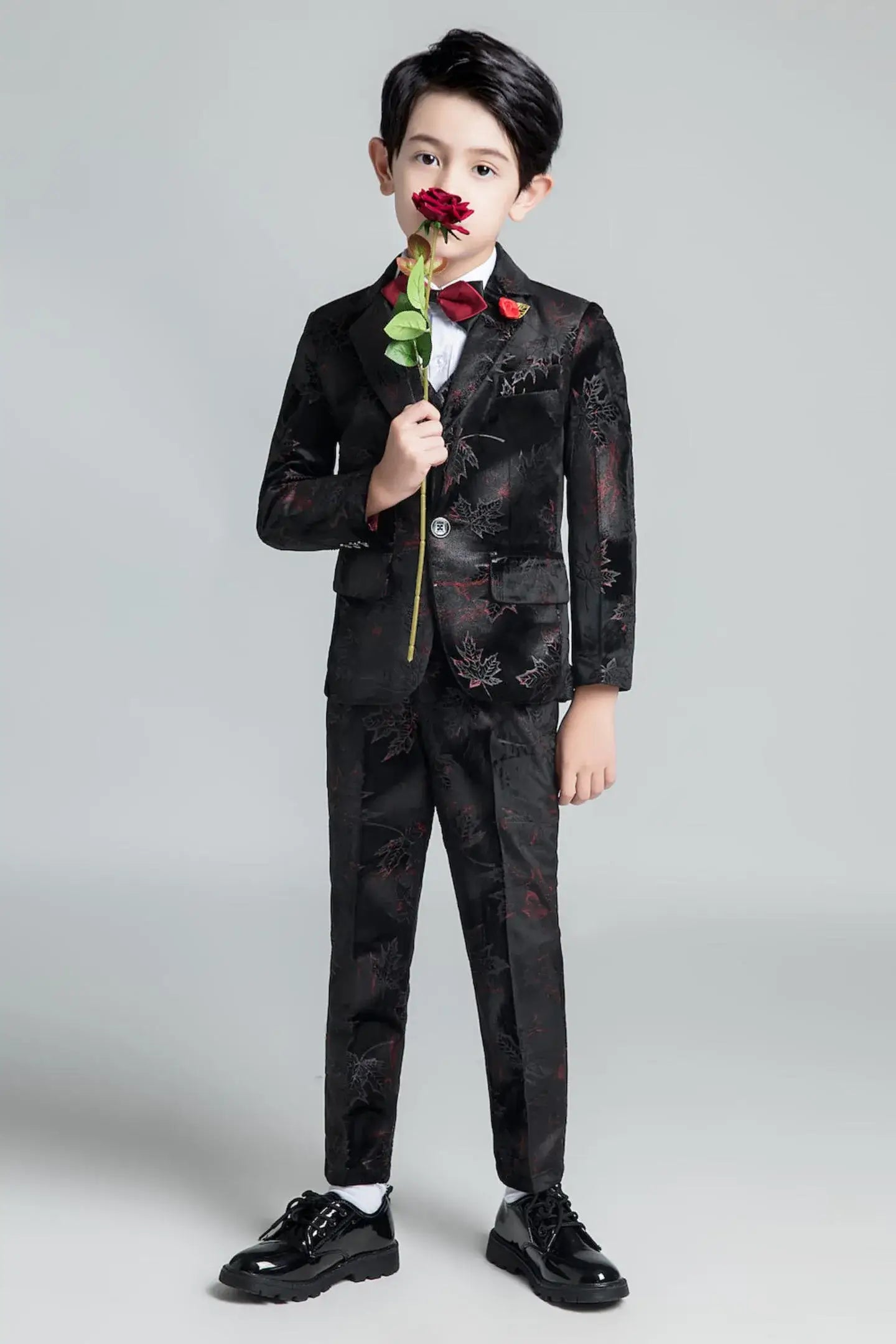 Black boys' floral suit with red maple print, red bow tie and lapel pin, ideal for graduations and special occasions