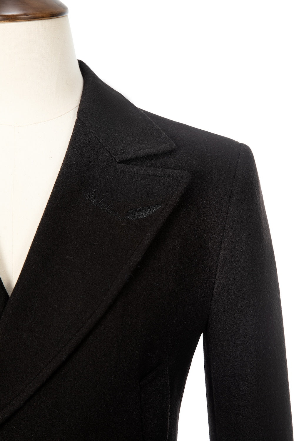 Close-up of peak lapel on black wool overcoat – men’s formal winter outer layer