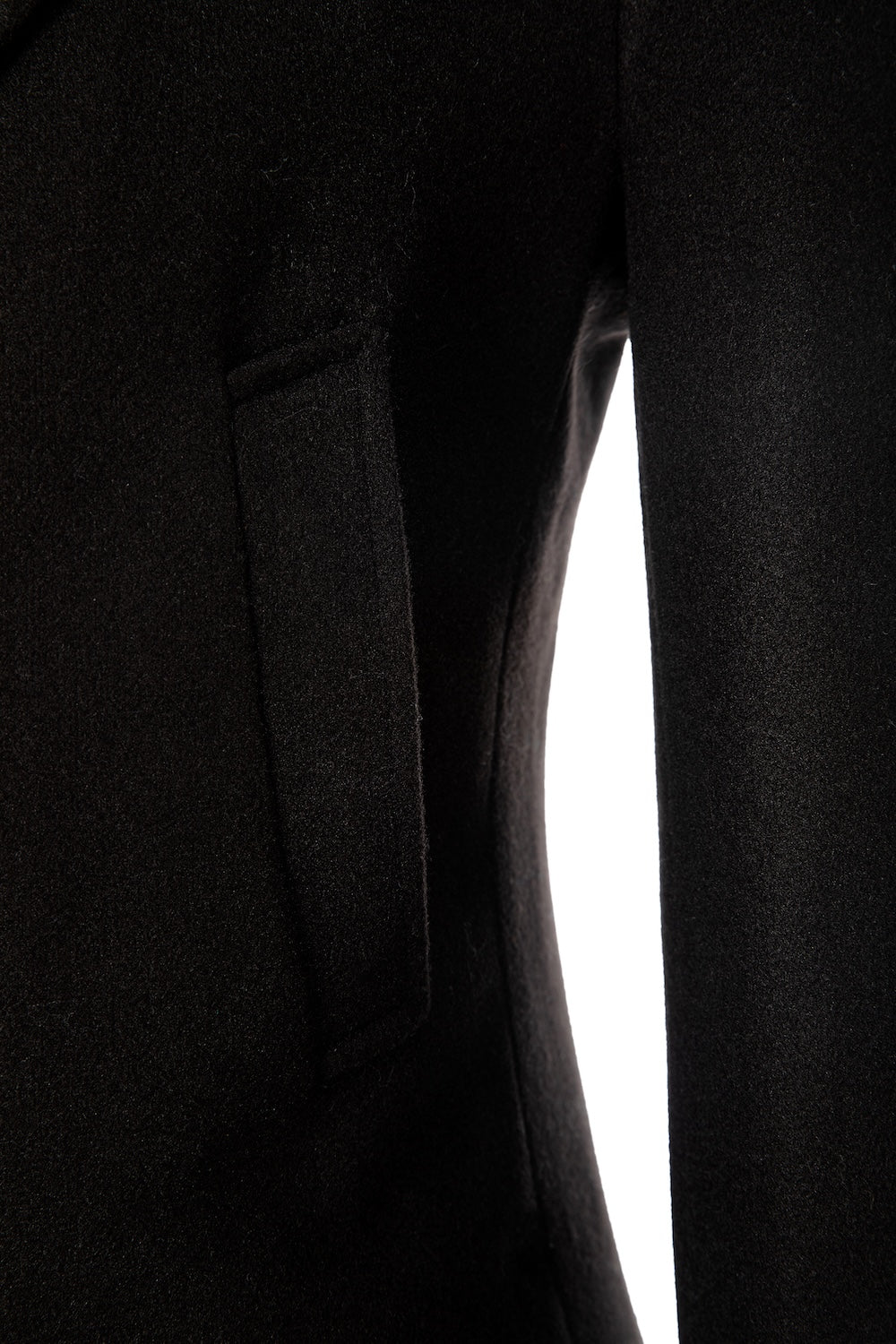 Detail view of pocket on black long men’s overcoat – wool texture and tailoring shown