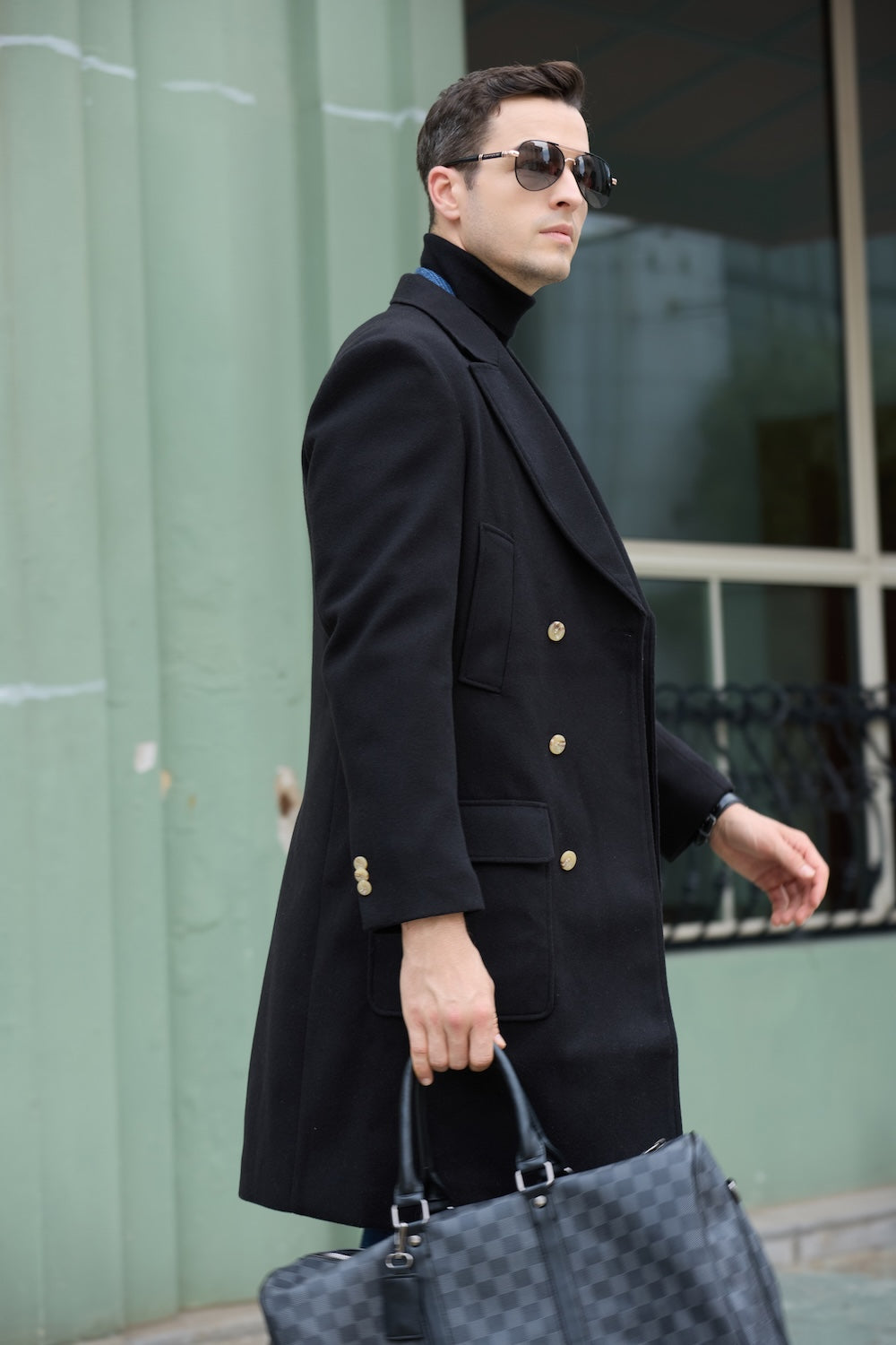 Side view of long black wool coat with gold buttons – modern winter menswear
