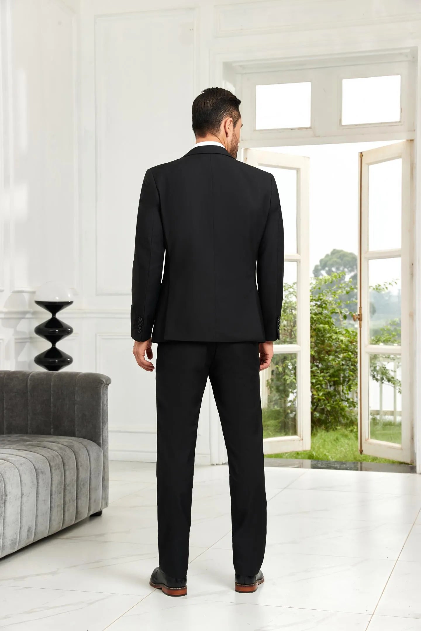 Back view of black 3 piece men's wedding suit showing fitted blazer and trousers for formal occasions.