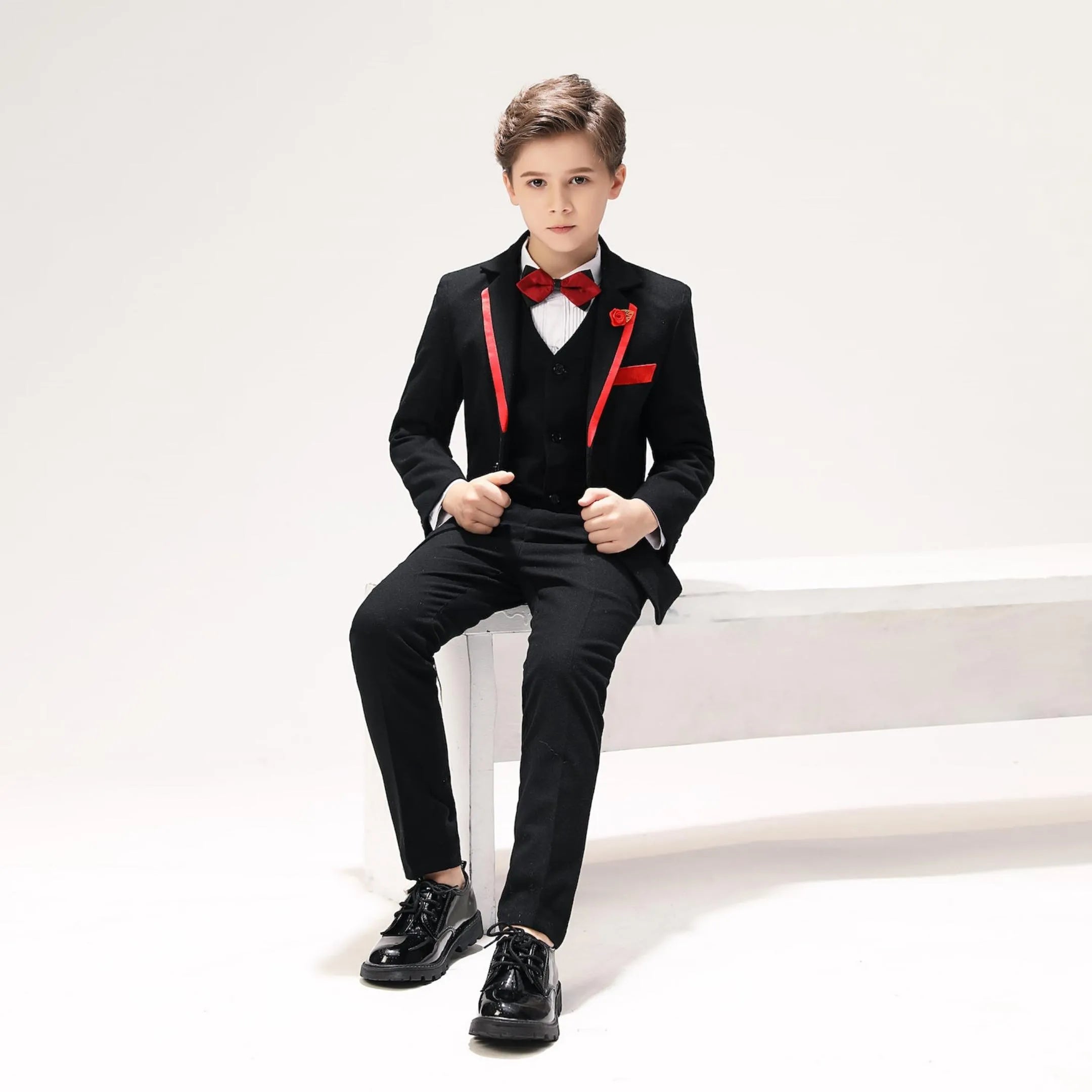 Stylish holiday boys suit 5-piece with black jacket, red accents, and bow tie for festive occasions