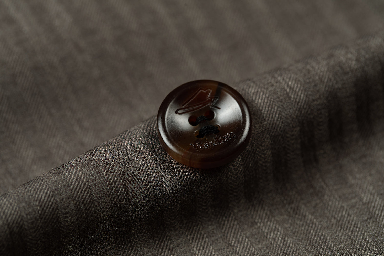 Detail shot of brown button on pinstripe men's blazer