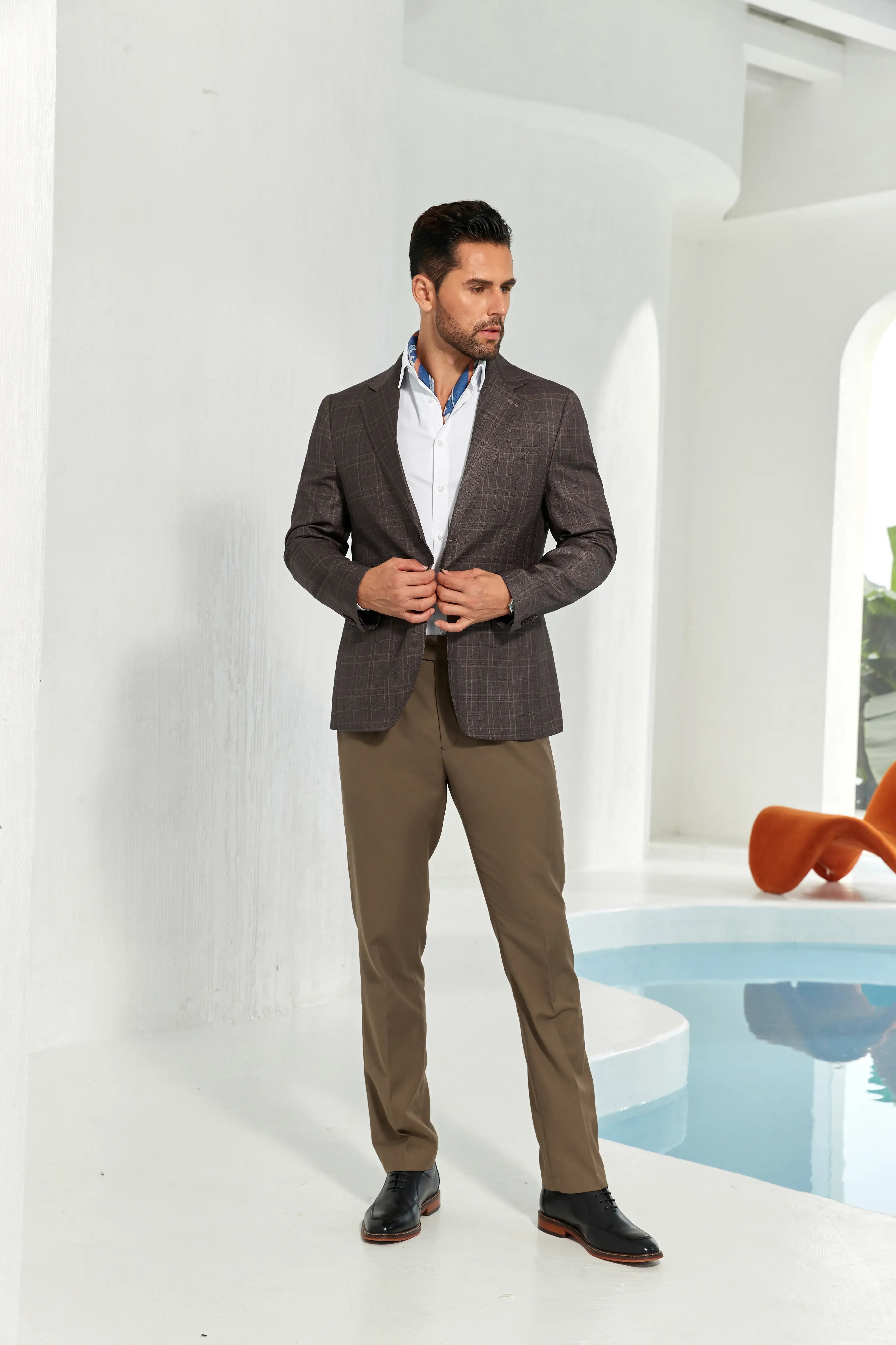 Full-length shot of man buttoning a coffee plaid two-button designer blazer