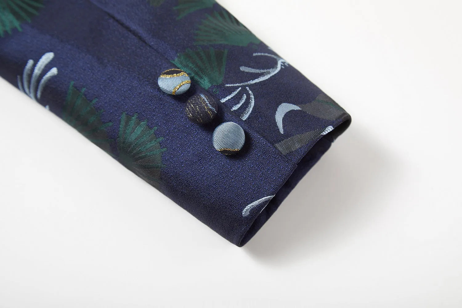 Blue boys' suit cuff: Tropical leaf print with gold-trimmed buttons, formal banquet event detail