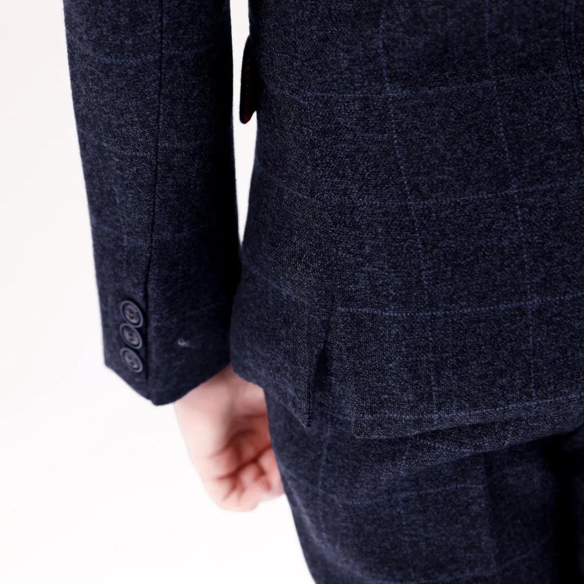 Close-up of sleeve and hem details on boys' plaid prom suit with soft wool fabric and button cuff