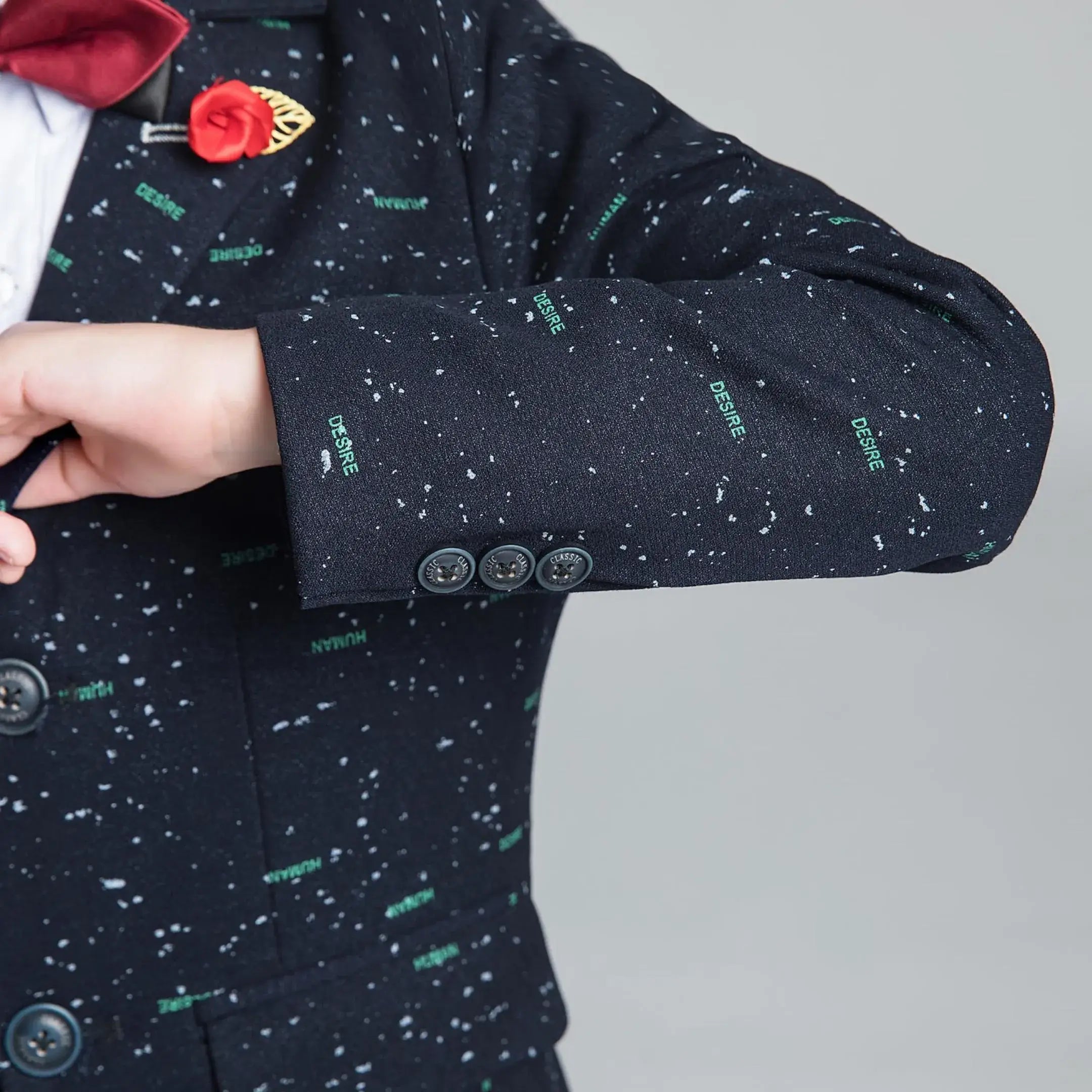 Detailed view of boys' printed suit sleeve with decorative cuff buttons, perfect for holiday events and stylish occasions