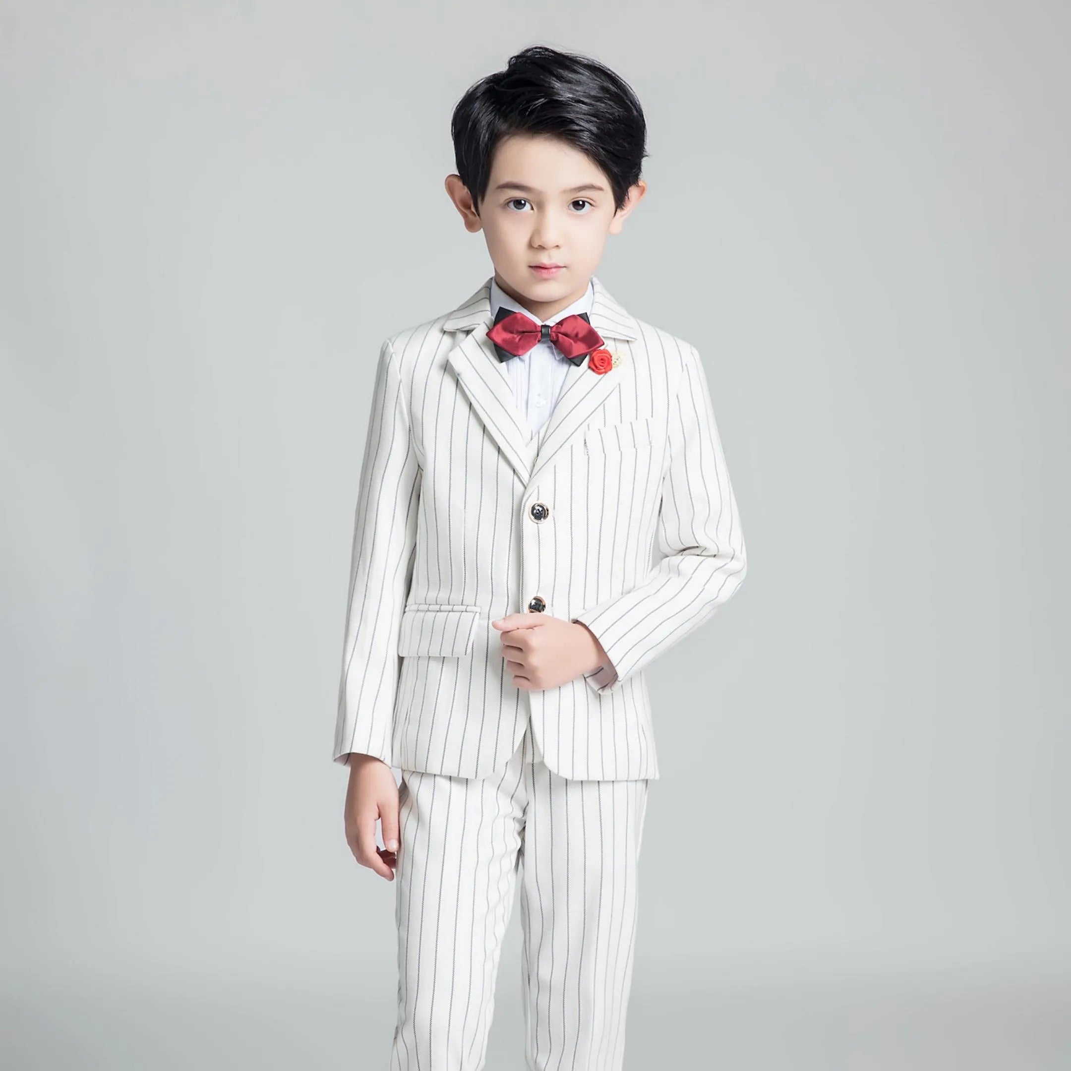 Classic boys striped white suit with red bow tie and flower pin
