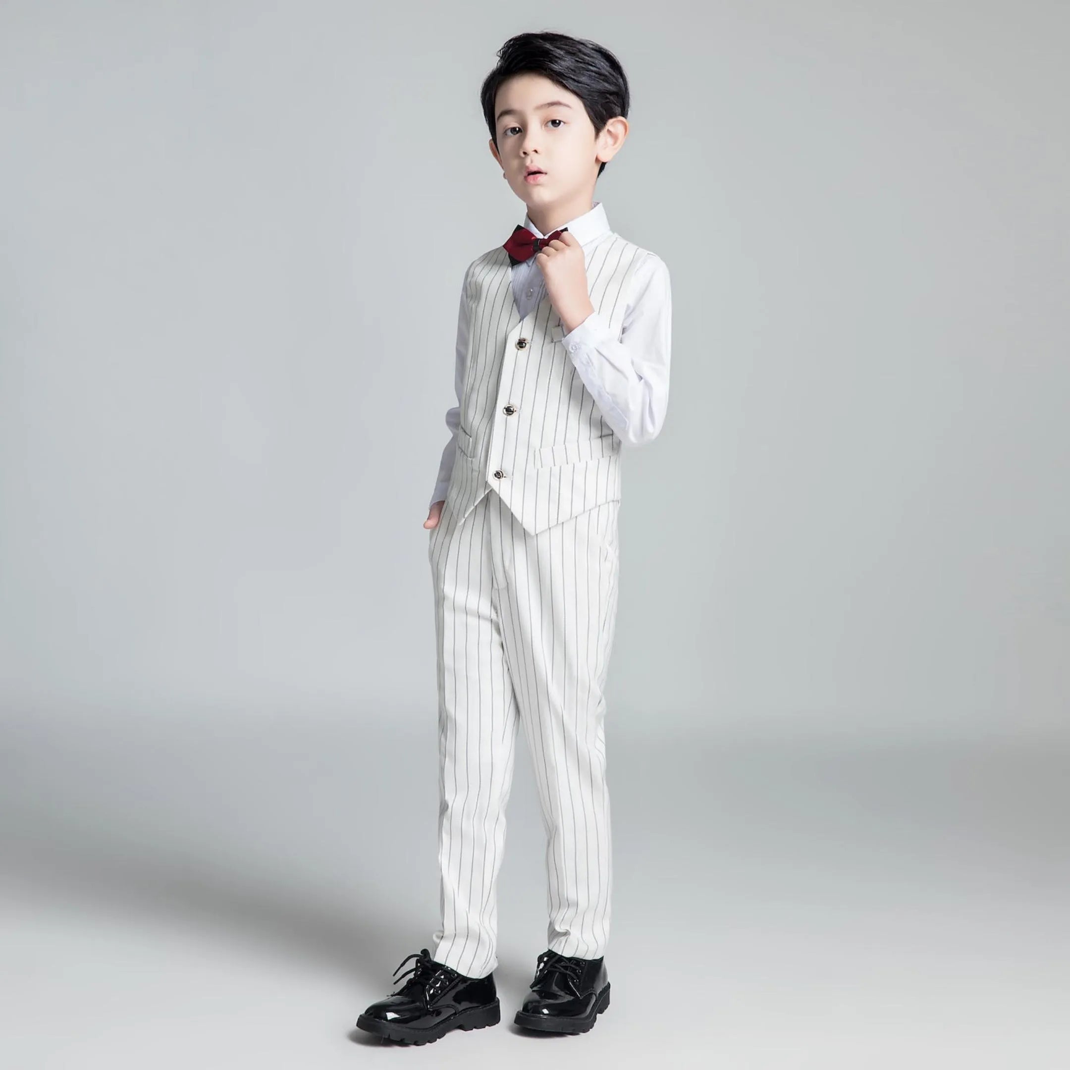 Stylish boys white striped suit vest and trousers with bow tie