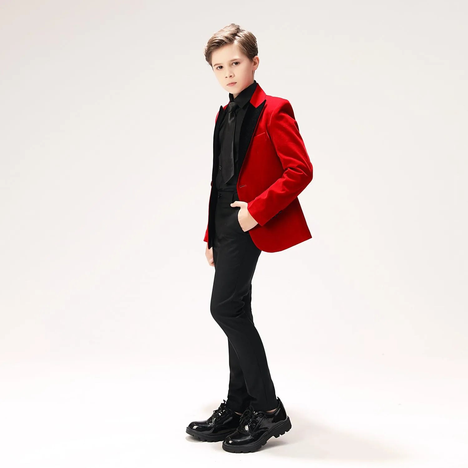 Formal red velvet suit for boys with contrasting black collar – side pose with hand in pocket