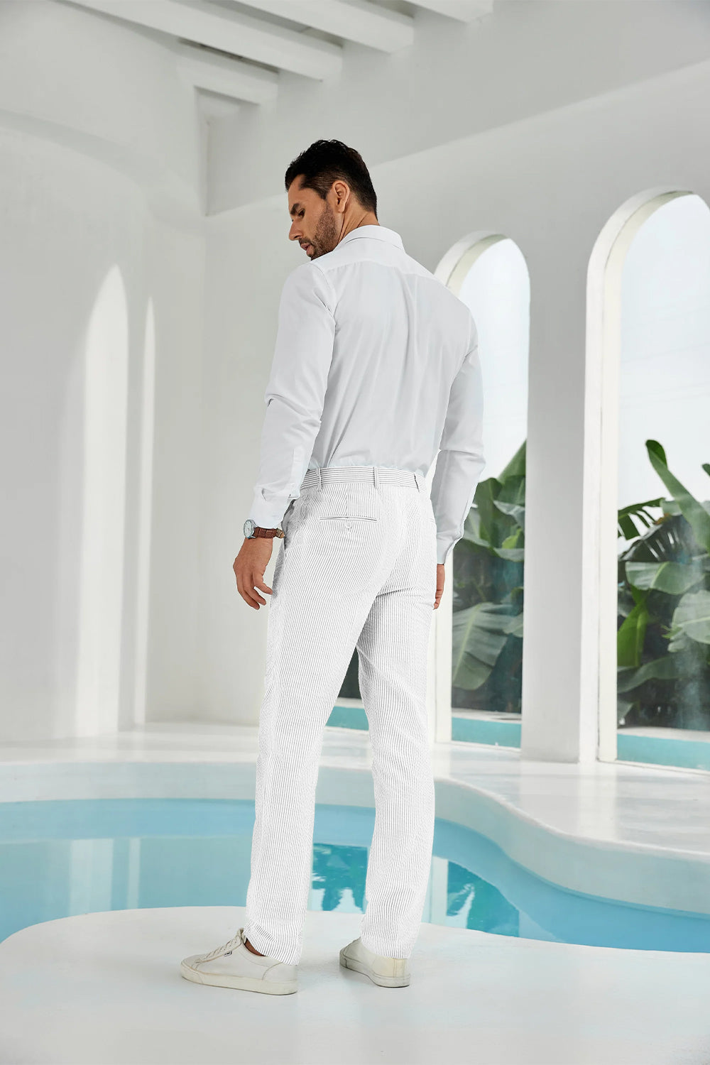 Full-body look: man in full white seersucker pants, white shirt, and sneakers