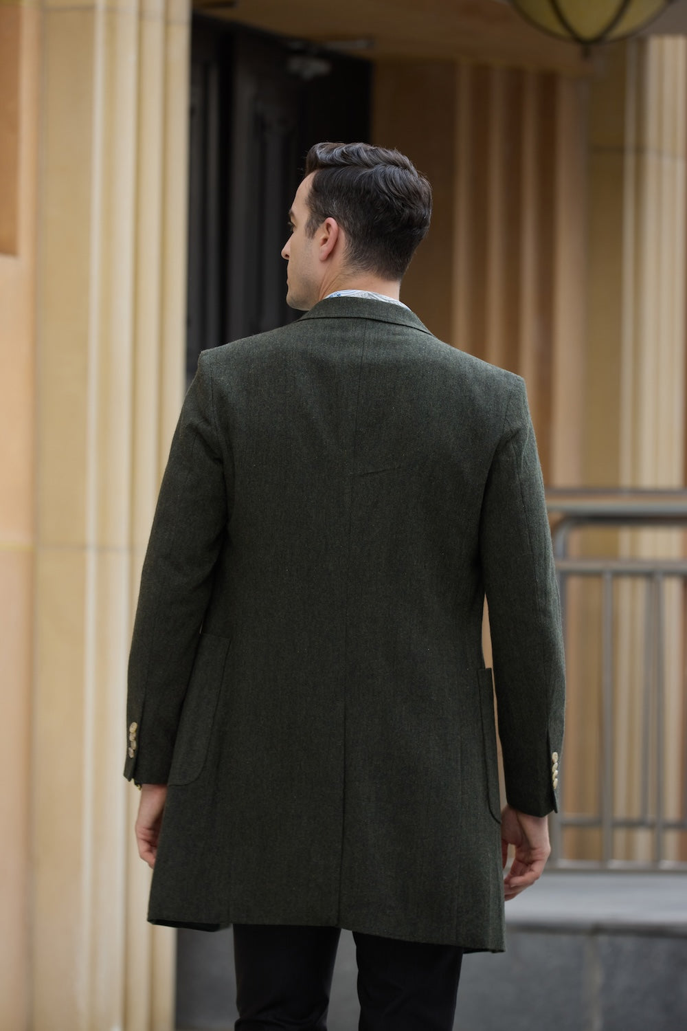 Back view of men’s green wool winter coat with structured fit and clean seam detail