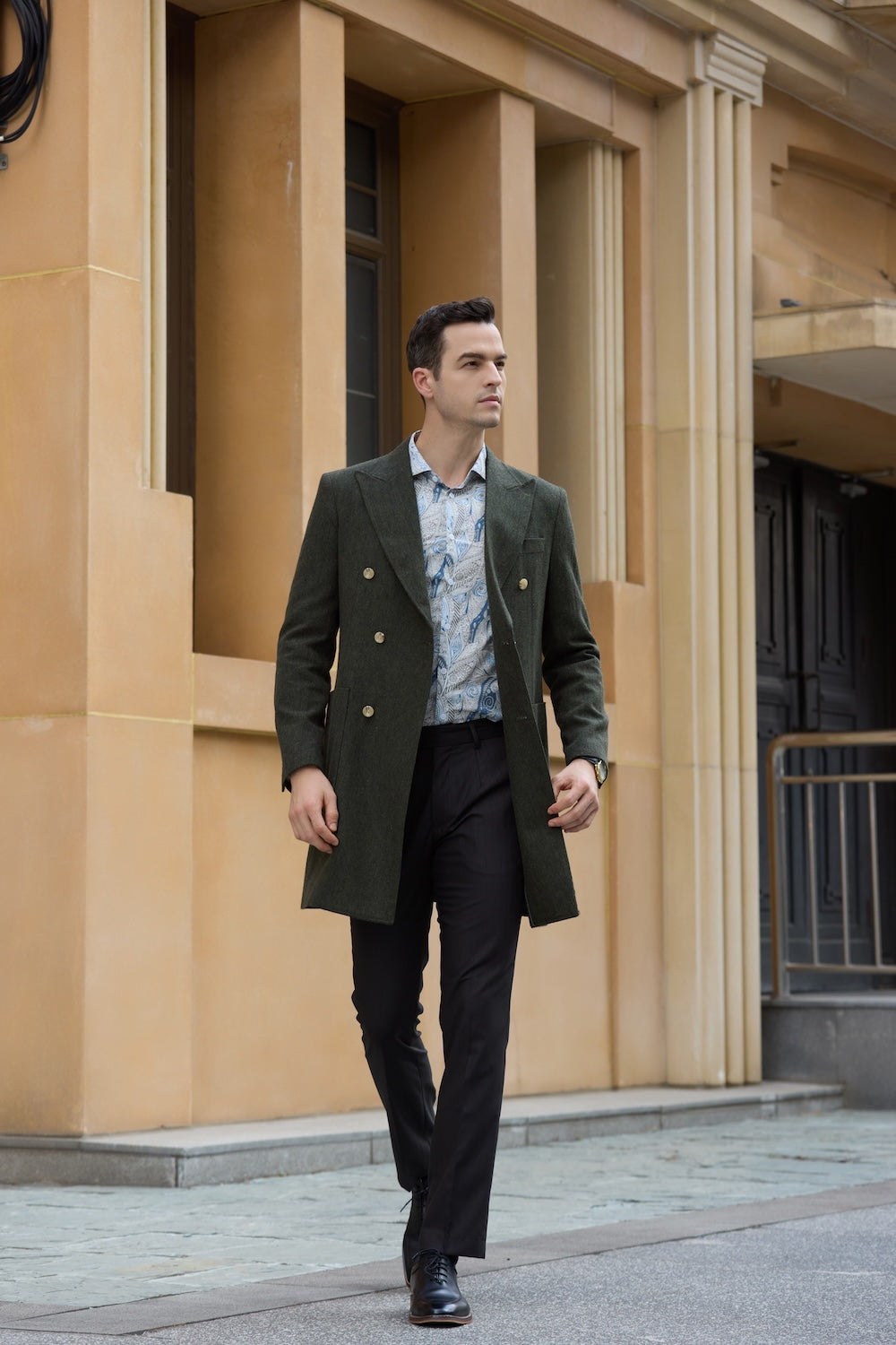 Full body shot of man in green long winter coat walking in city street style outfit