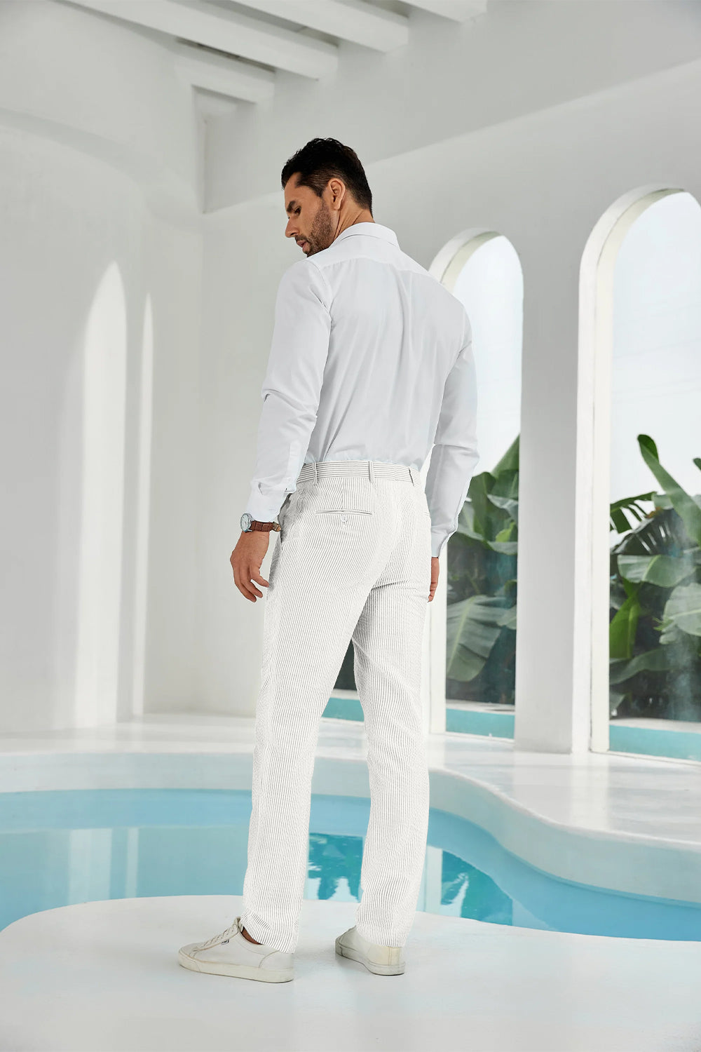 Full-body look: man in ivory white seersucker pants, white shirt, and sneakers