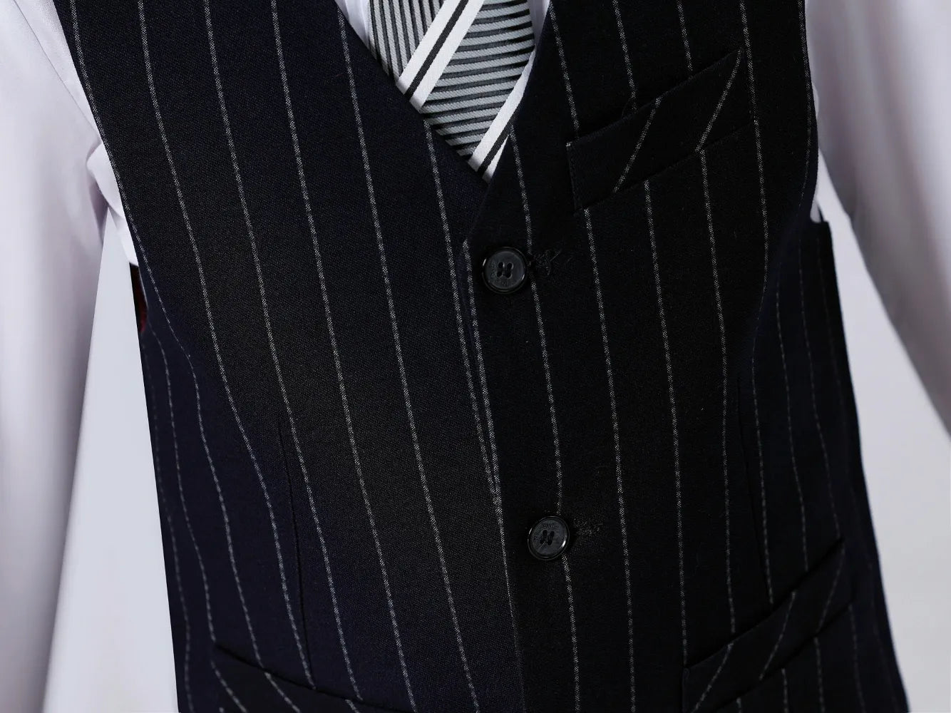 Detailed view of buttons and pocket on navy pinstripe vest – sharp boys' formal suit design