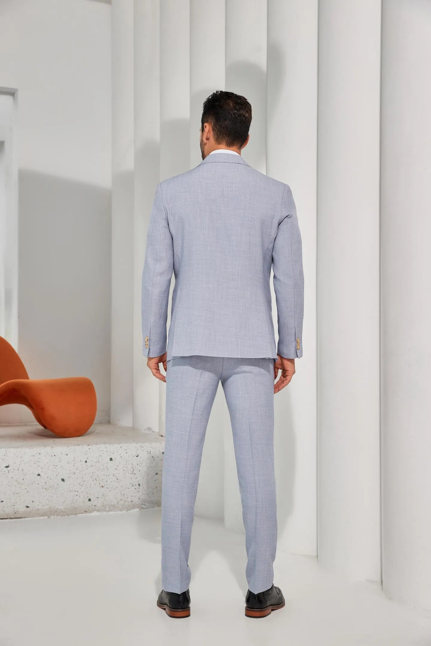 model wearing a light blue summer vest suit, paired with matching trousers, offering a modern look for casual events.