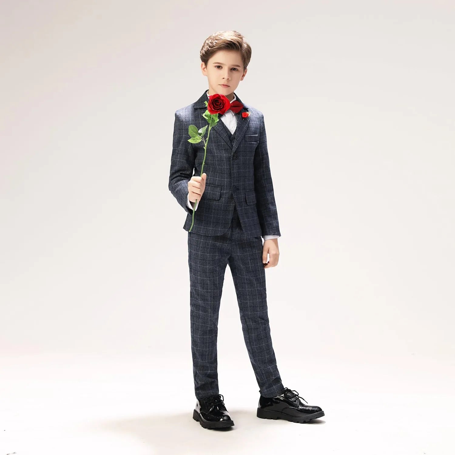 Little boy grey checkered suit with red boutonnière and bow tie, styled for page boy or party