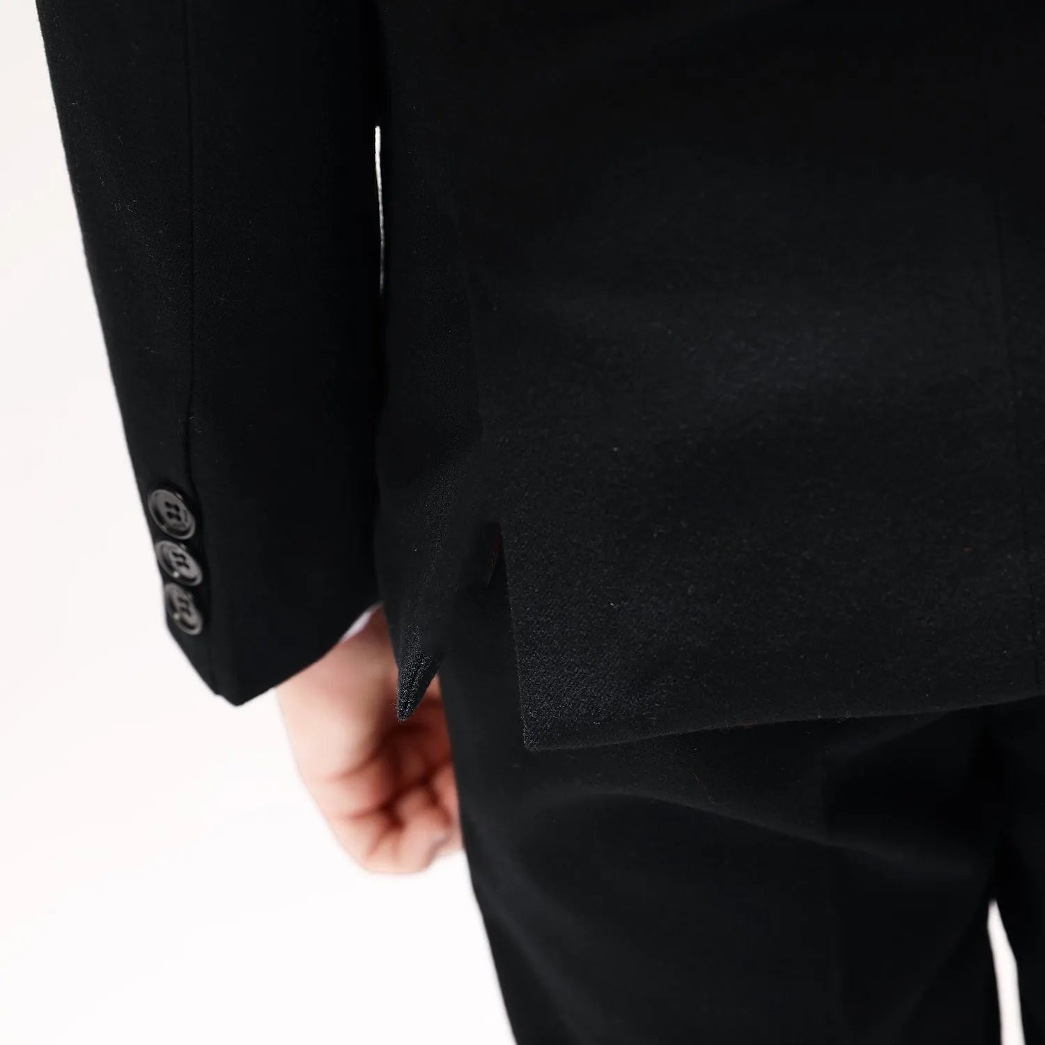 Rear vent detail of boys' prom suit with tailored hemline and sleeve cuff buttons, close-up view