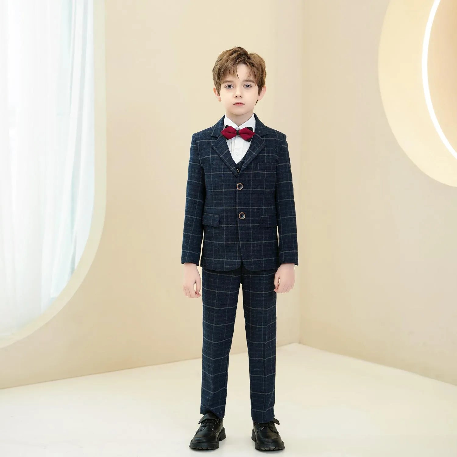 Slim fit navy plaid boys 5-piece suit: Front view with red bow tie & modern formal style