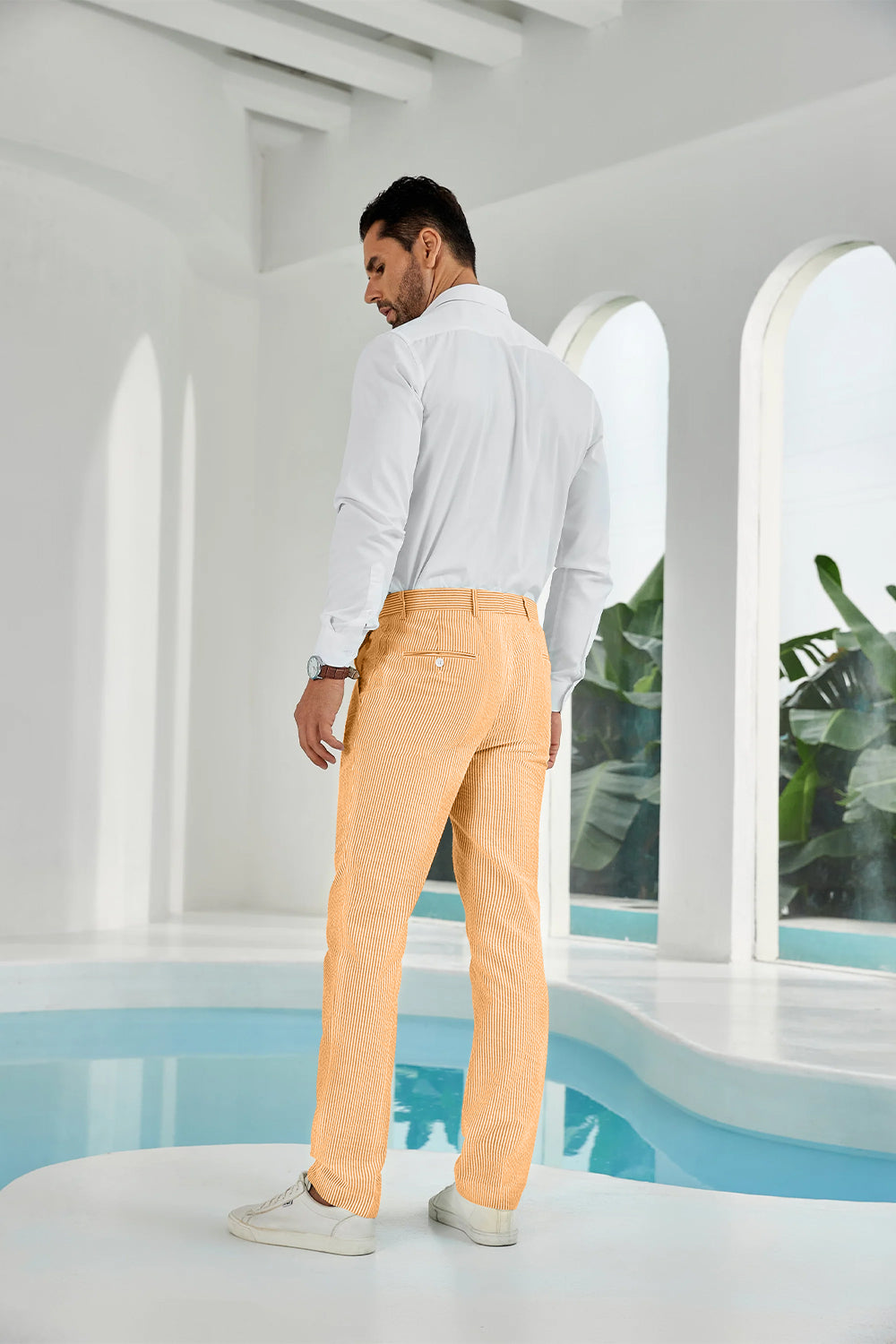 Three-quarter rear angle of orange pants showing slim fit and texture