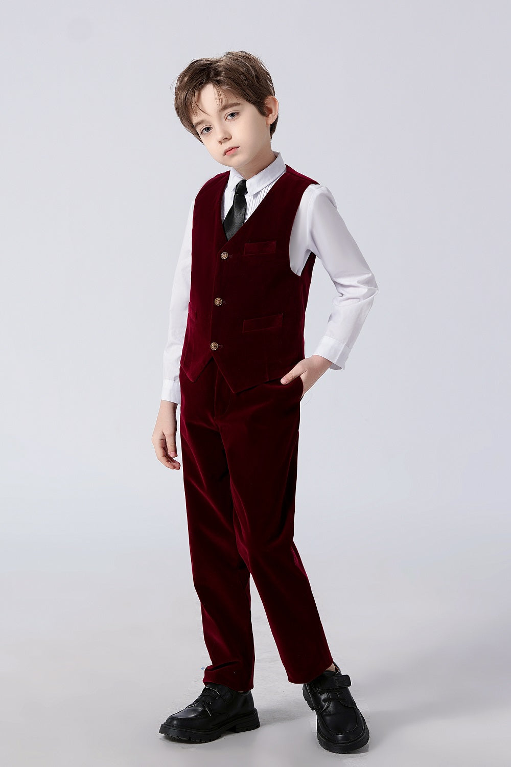 Boy wearing burgundy velvet 2-piece suit: Vest with gold buttons, pants & black tie – formal kids' outfit