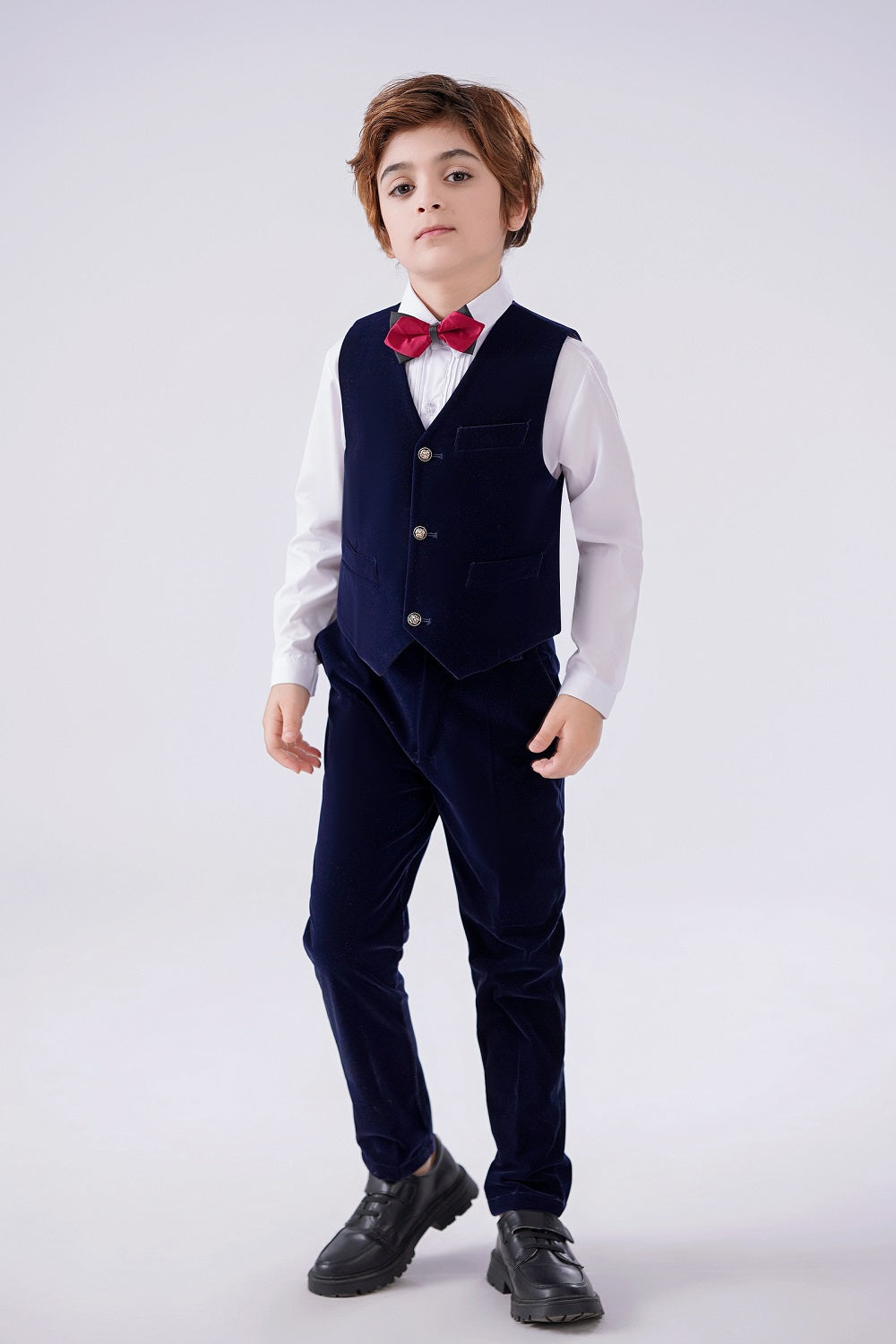 Boy in navy velvet 2-piece suit: Vest with gold buttons, pants & red bow tie – formal kids' outfit