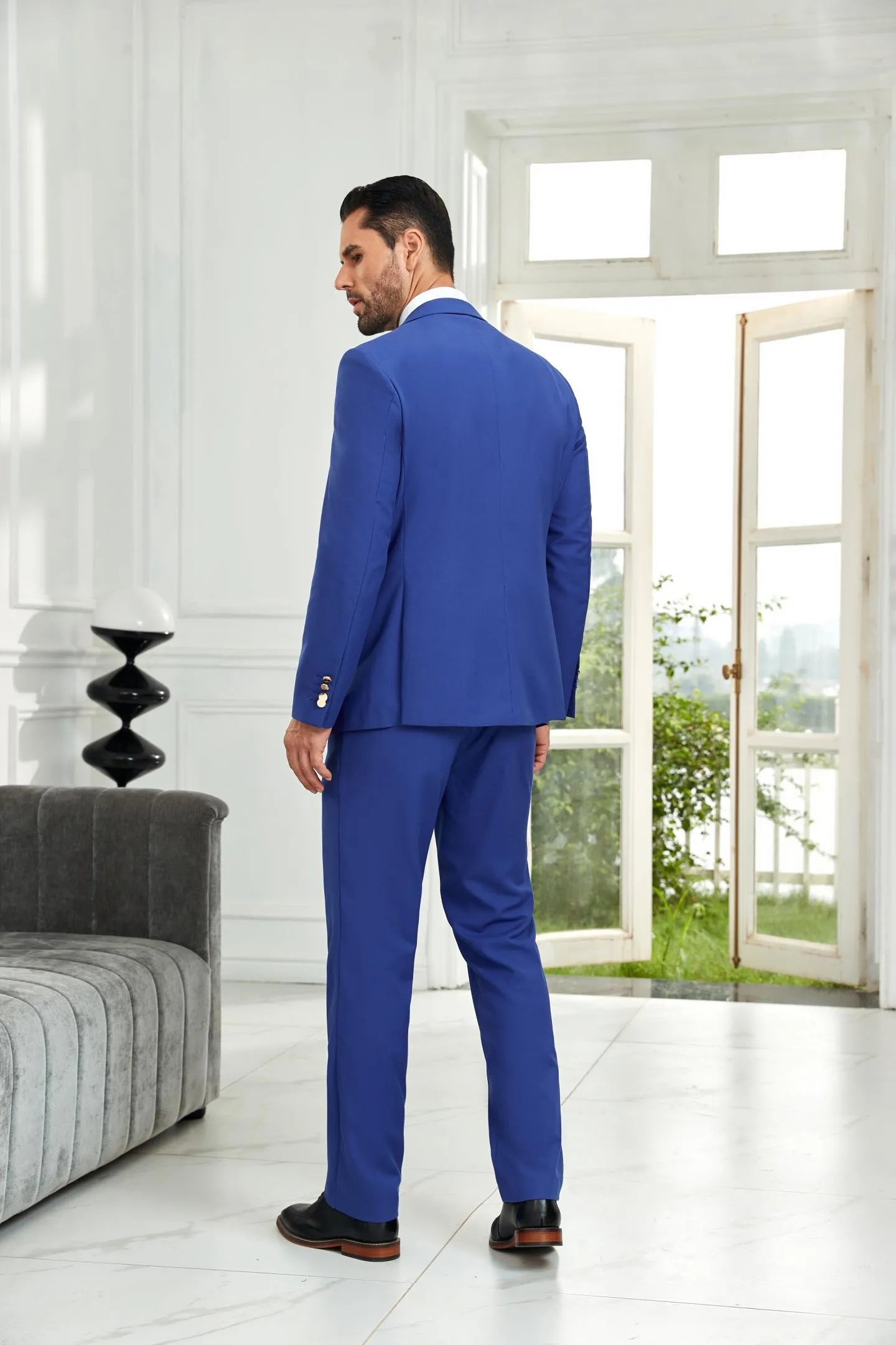 Back view of royal blue 3 piece men's suit featuring tailored blazer and pants, highlighting sleek formal style.