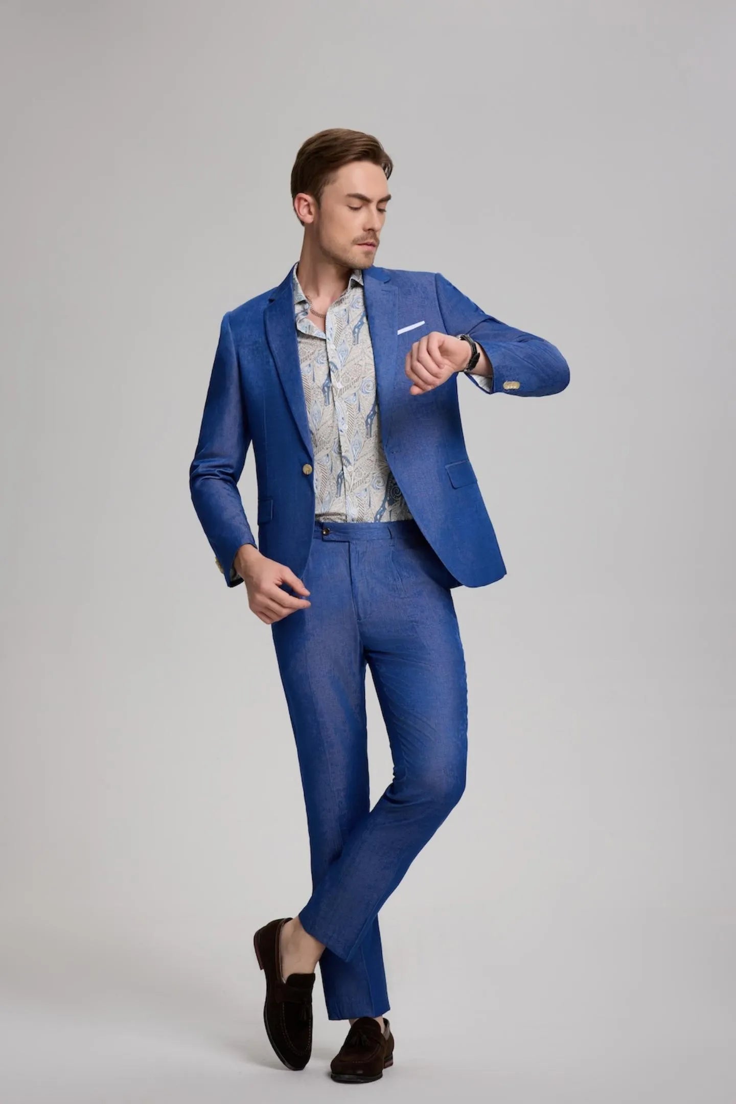 men wearing royal blue casual slim fit 2-piece suit, checking his watch while showcasing notch lapel blazer and slim trousers for a polished look.