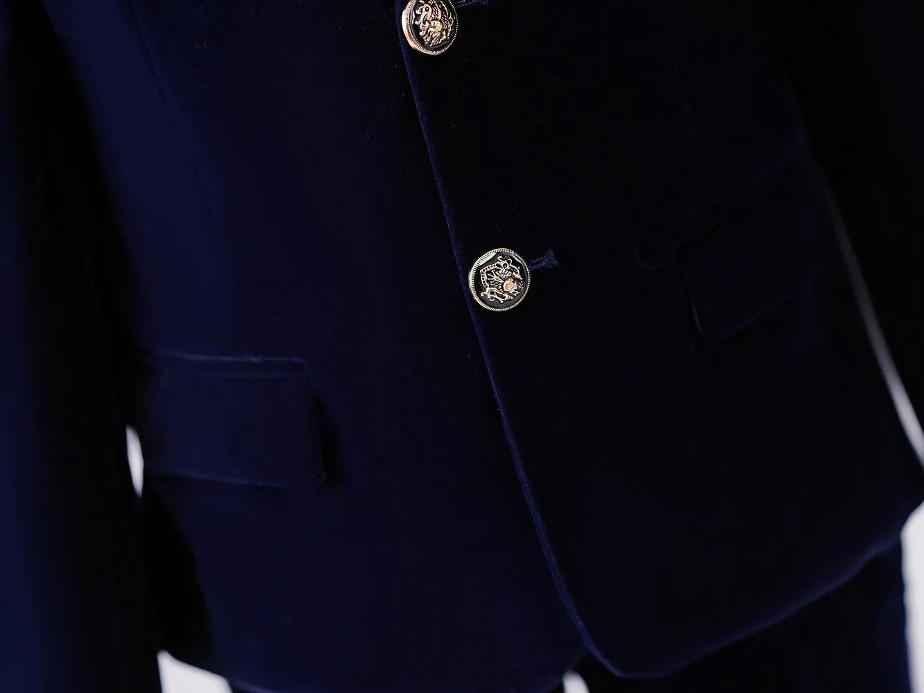 Detail shot of blazer pocket and button – navy velvet boy’s formal jacket design