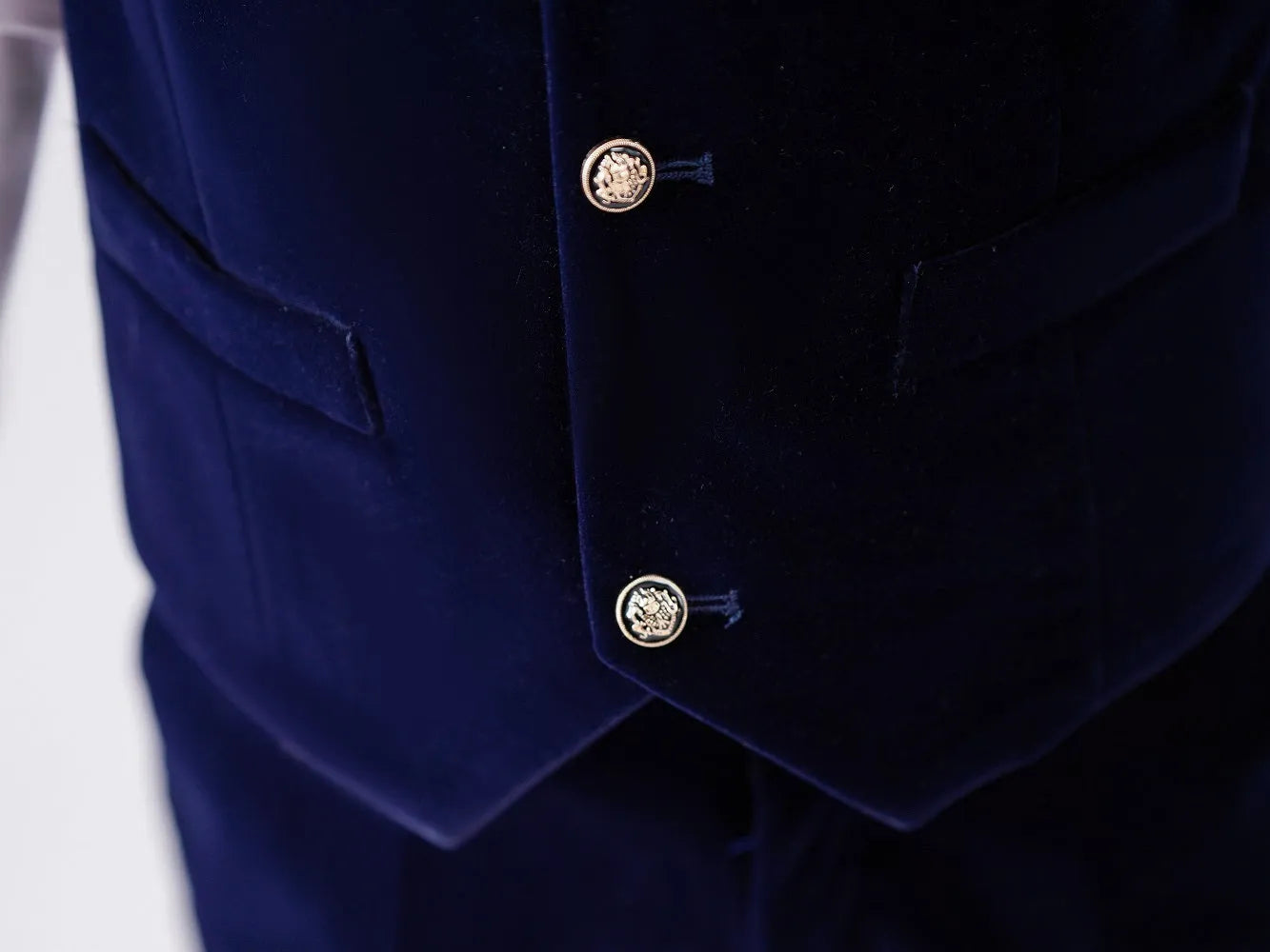 Close-up of velvet vest pockets and buttons – navy boy’s formalwear with gold detailing