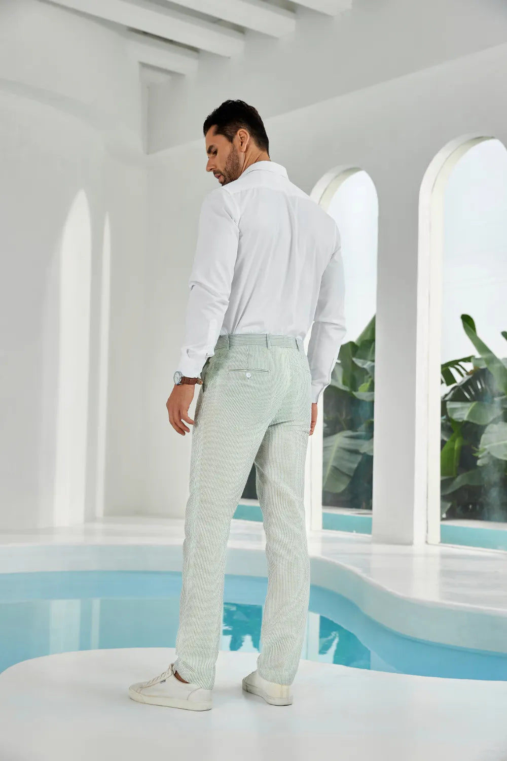 Three-quarter rear view of slim-fit sage green seersucker pants, showcasing their texture and lightweight design.