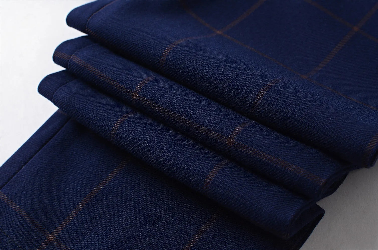 Blue plaid boys suit fabric: Close-up of navy checkered material with gold lines