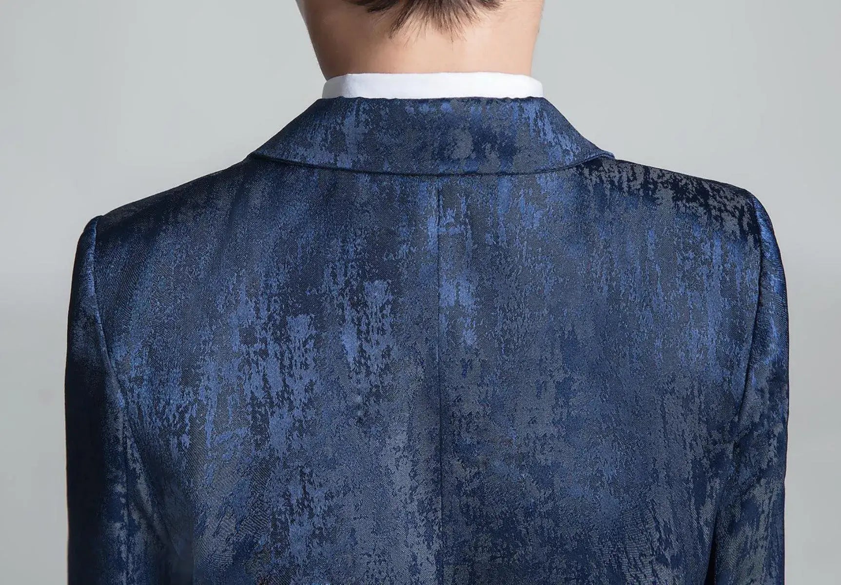 Close-up back view of navy floral textured boys' suit jacket with elegant notch collar detail