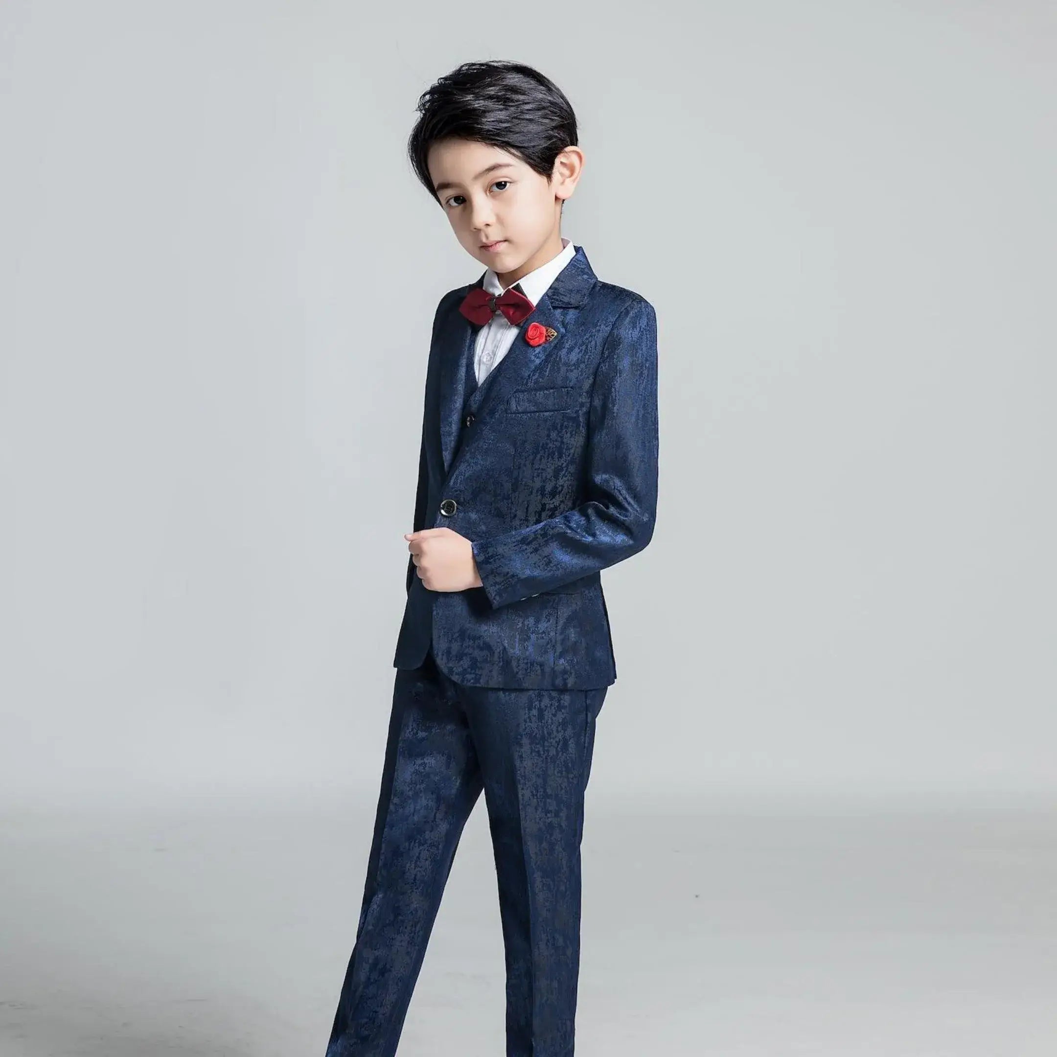 Navy textured boys' suit with red bow tie and rose pin, slim fit formal outfit for weddings or parties