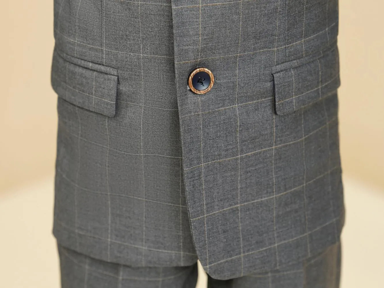 Grey plaid boys suit: Close-up of button & checked blazer front detail
