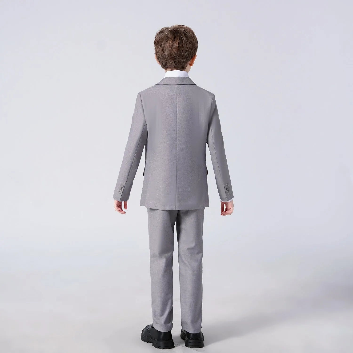 Back view of light grey boys suit with tailored jacket and button detail suitable for ceremonies