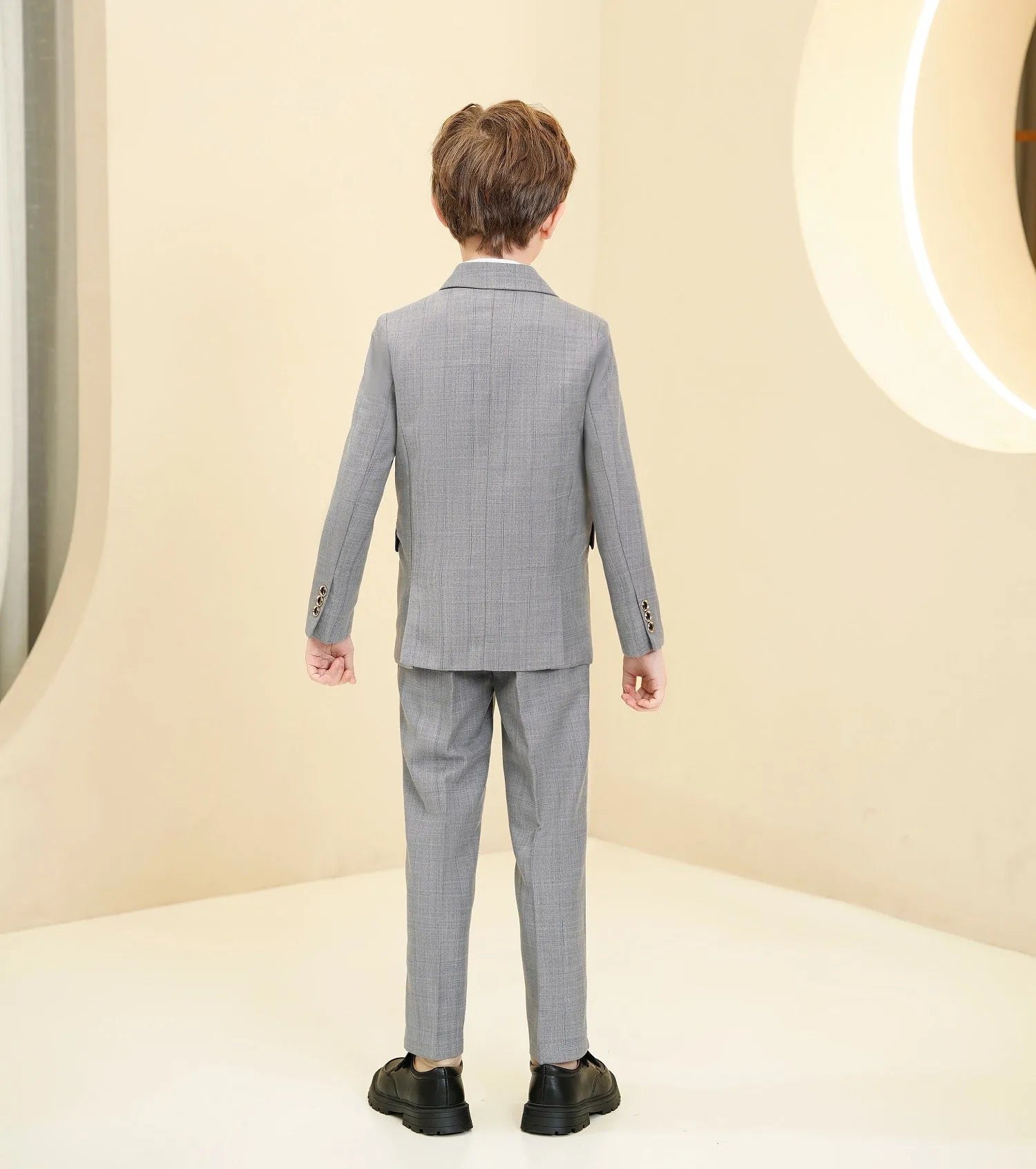 Back view of light grey plaid boys suit showcasing classic tailoring and slim fit.