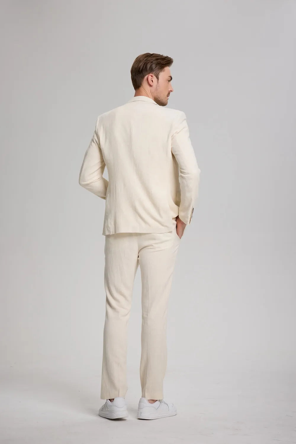 Back view of men's beige linen suit – casual blazer and pants outfit styled with white sneakers